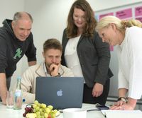 Marcus Kolb, Katharina Temme und Gabriele Unützer stehen, Phineas Speicher sitzt am Notebook - alle in Diskussion